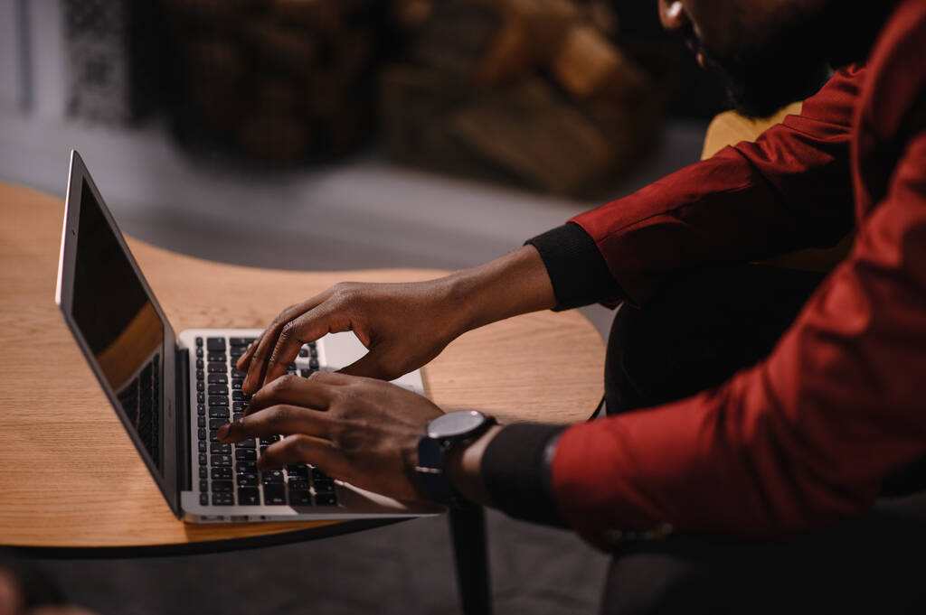 Αρσενικός αφρικανός αμερικανός χρήστης χέρια δακτυλογράφηση στο πληκτρολόγιο laptop κάθονται στο τραπέζι, μικτή φυλή εθνοτικής φοιτητής επαγγελματική μελέτη εργασία με την έννοια της τεχνολογίας λογισμικού PC, close up view - Φωτογραφία, εικόνα