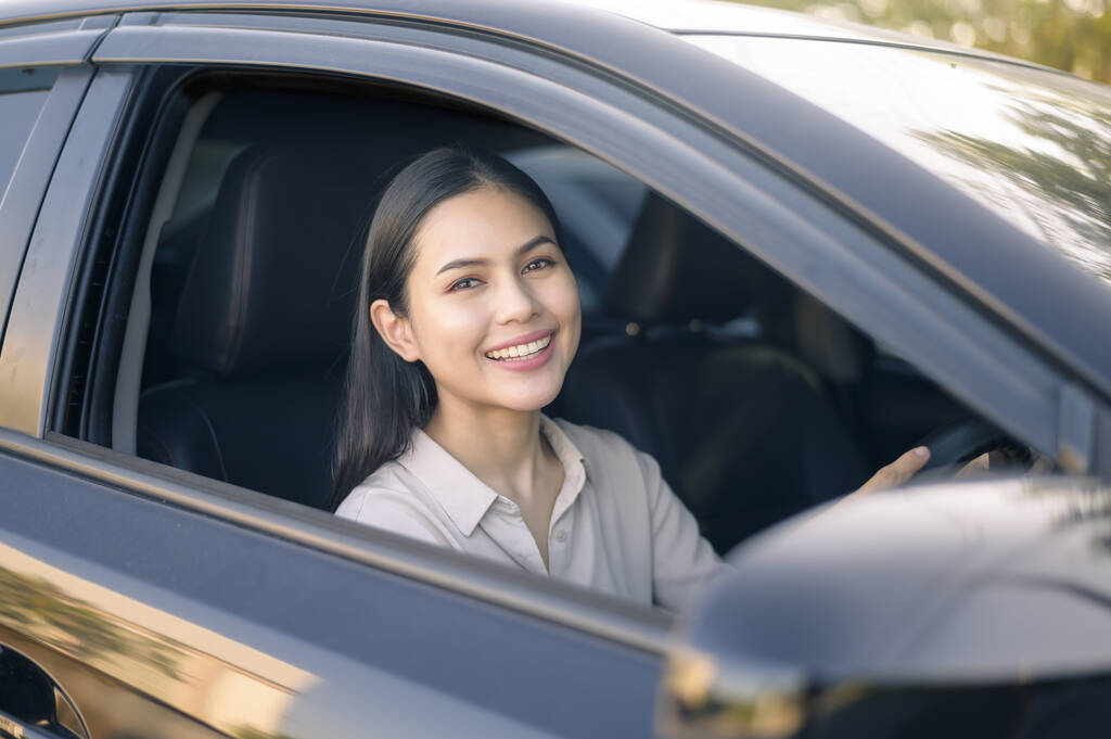 Une belle jeune femme souriante au volant de sa voiture, concept d'assurance et de finance - Photo, image