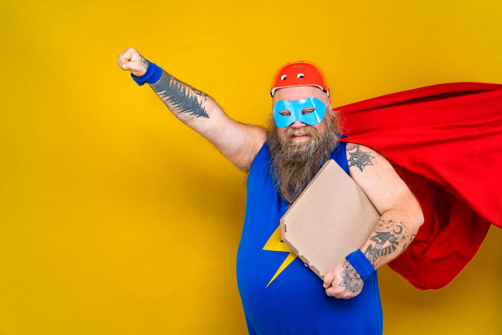 Süper kahraman kostümlü komik şişman adam özel güçleri olan süper insan rolünde, renkli arka planda bir portre. - Fotoğraf, Görsel