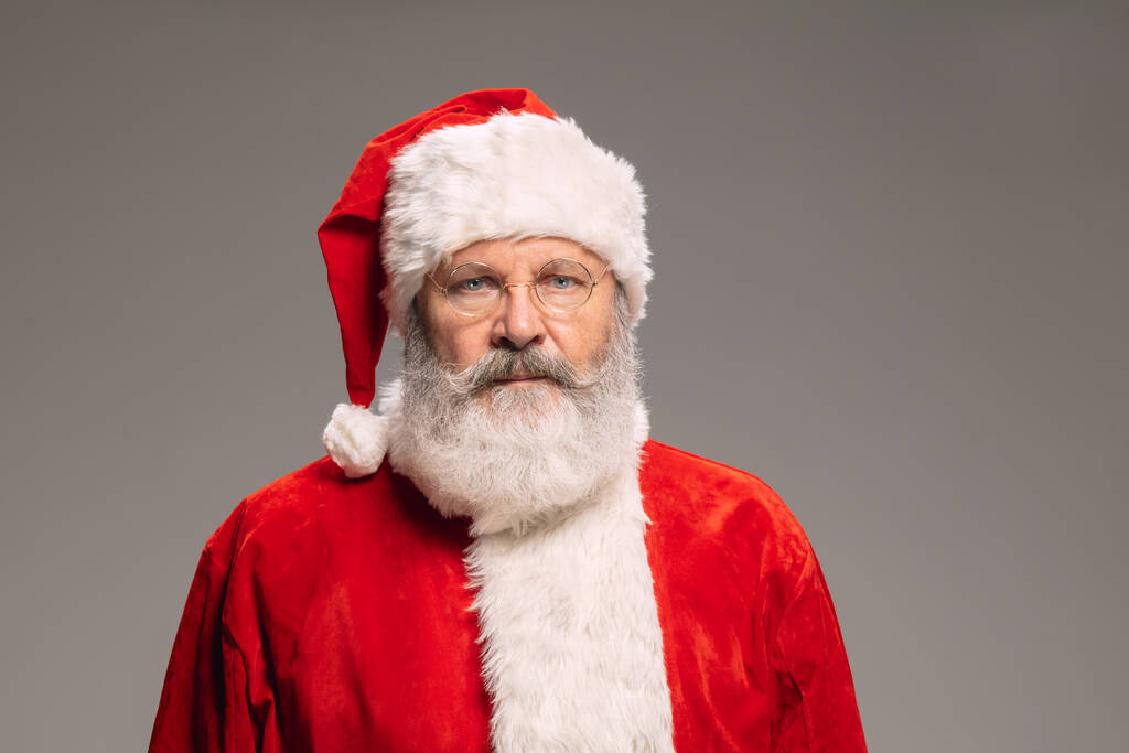 Starší muž jako Santa Claus izolované na šedém pozadí studia - Fotografie, Obrázek