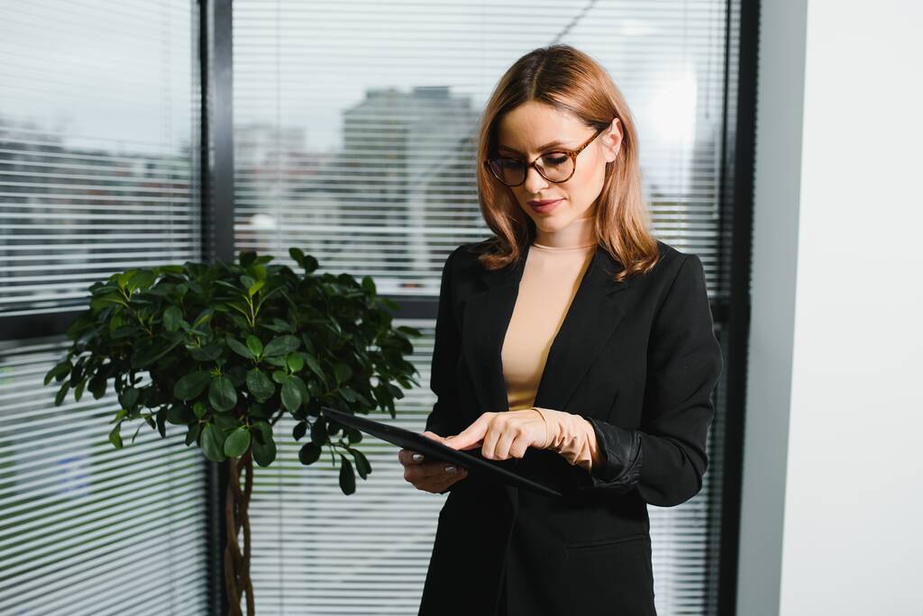 Porträt einer Geschäftsfrau mittleren Alters, die mit einem digitalen Tablet im Büro steht. Geschäftsleute. - Foto, Bild