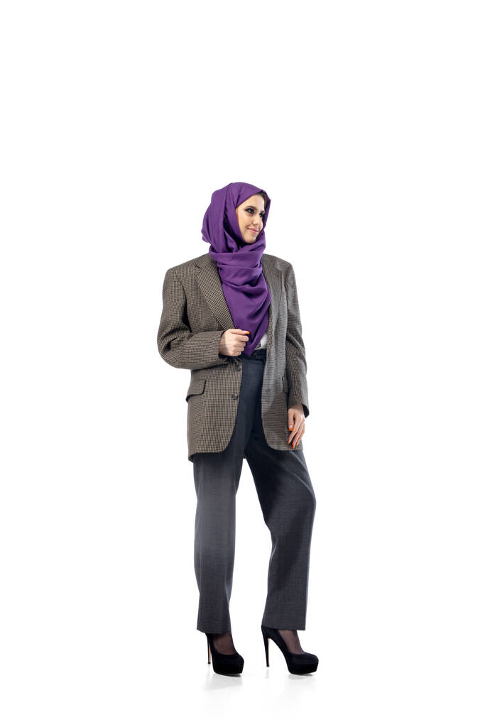 Hermosa mujer árabe posando en elegante atuendo de oficina aislado en el fondo del estudio. Concepto de moda - Foto, imagen