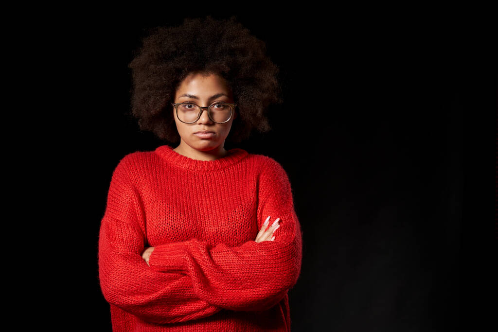 Ofendida enfurruñada joven afroamericana en gafas con las manos dobladas - Foto, imagen