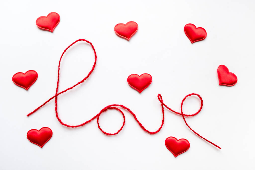 Koncepcja Walentynek. Czerwone serce i słowo miłość wykonane z wełnianej liny na białym tle - Zdjęcie, obraz