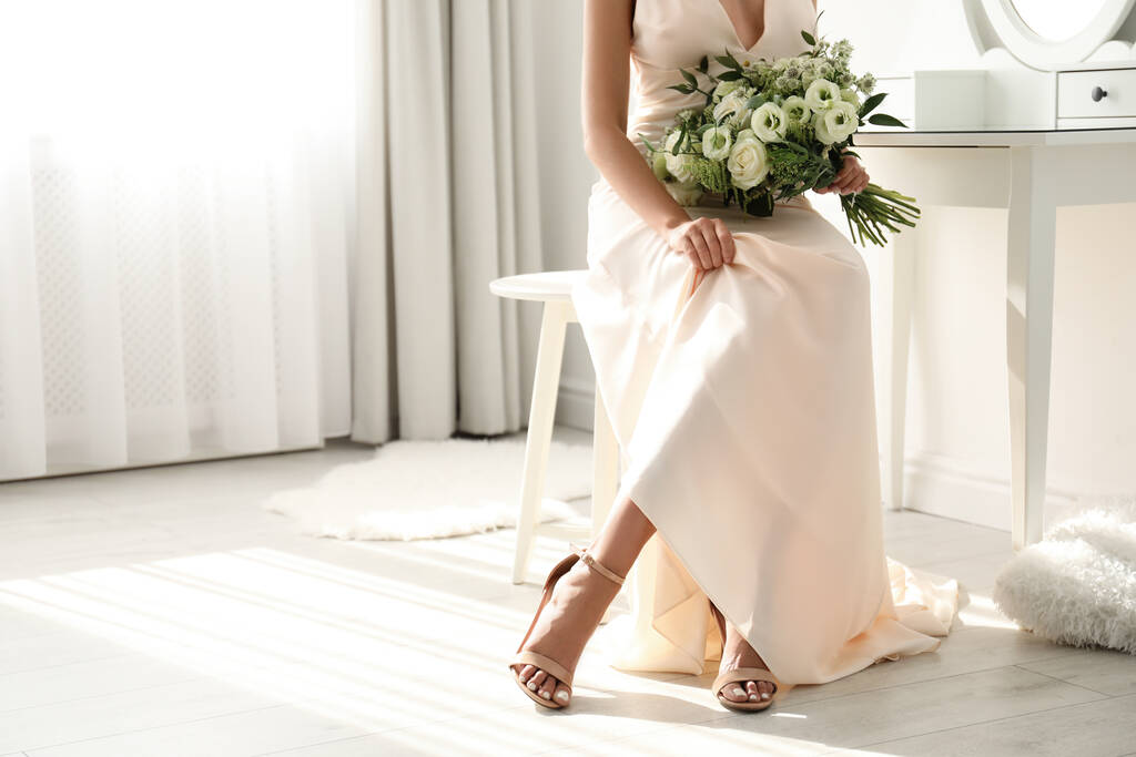 Молодая невеста в свадебном платье с красивым букетом возле зеркала в помещении, крупным планом. Пространство для текста - Фото, изображение