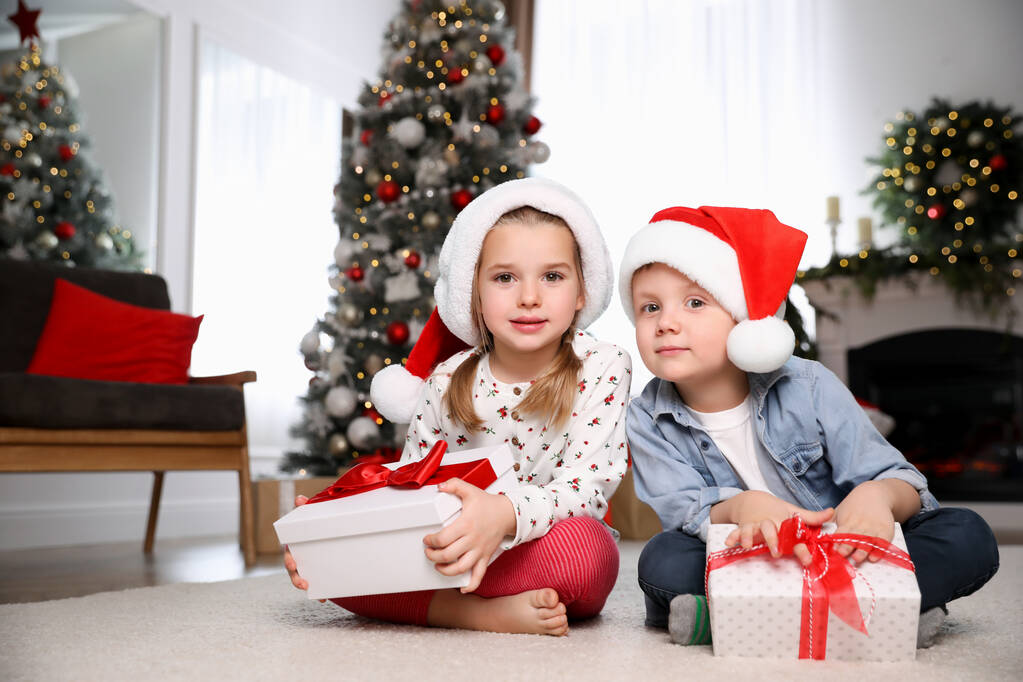 Carino i bambini piccoli con regali di Natale sul pavimento a casa - Foto, immagini