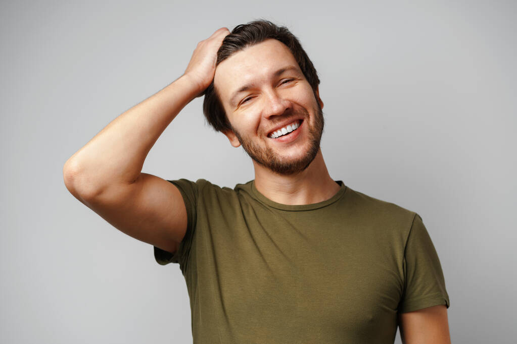 Jóképű fiatalember portré mosolyogva szürke háttér - Fotó, kép