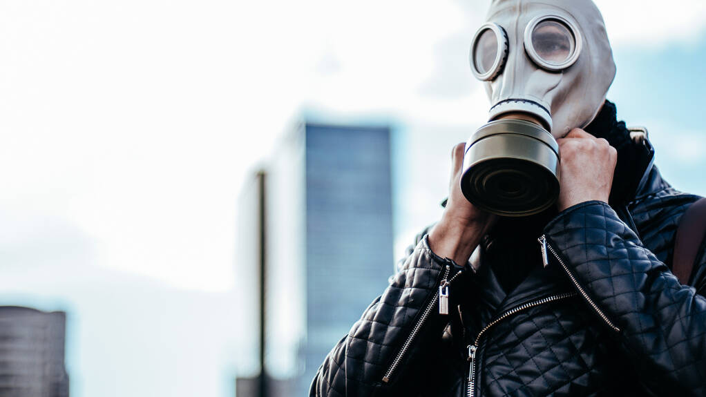 jeune homme portant un masque à gaz dans une rue de la ville - Photo, image