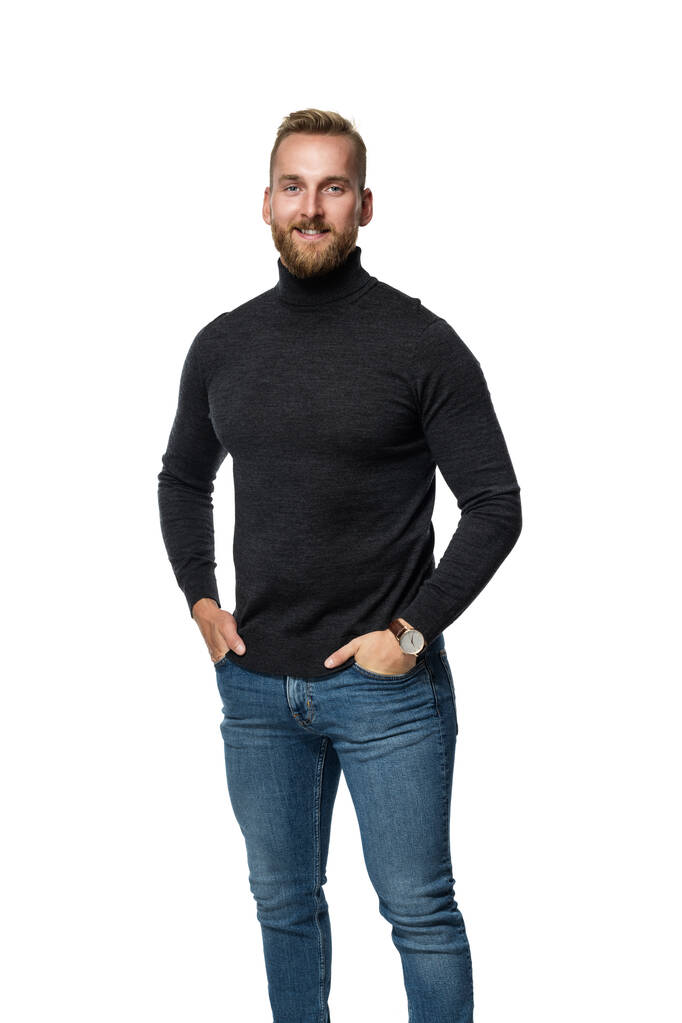 Smiling blonde man in long-armed sweater, standing against a white background. - Fotó, kép