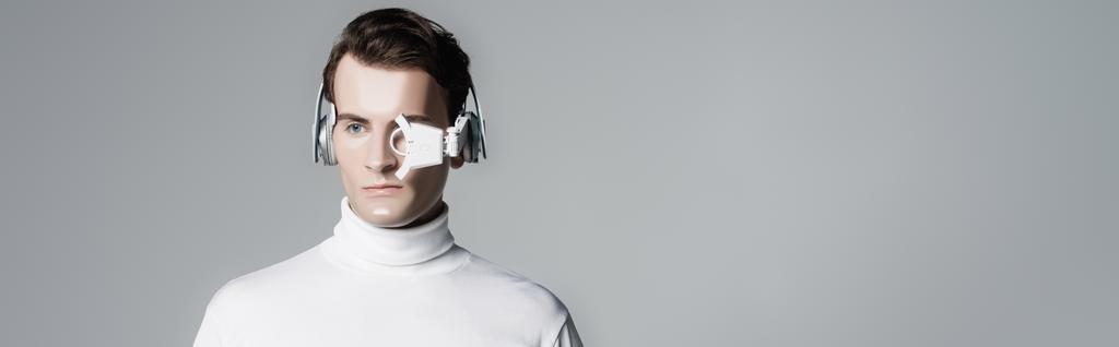 Cyborg en lente de ojo digital y auriculares aislados en gris con espacio para copias, banner - Foto, Imagen