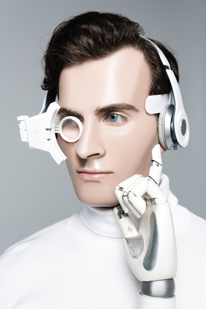 デジタル眼レンズ、ヘッドフォンや人工的な手の距離グレーで隔離された見てのサイボーグ男 - 写真・画像