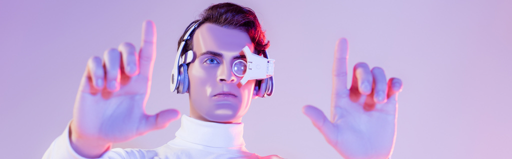 Dijital gözlüklü ve kulaklıklı Cyborg adam mor arka planda bulanık bir ön plan kullanıyor. - Fotoğraf, Görsel