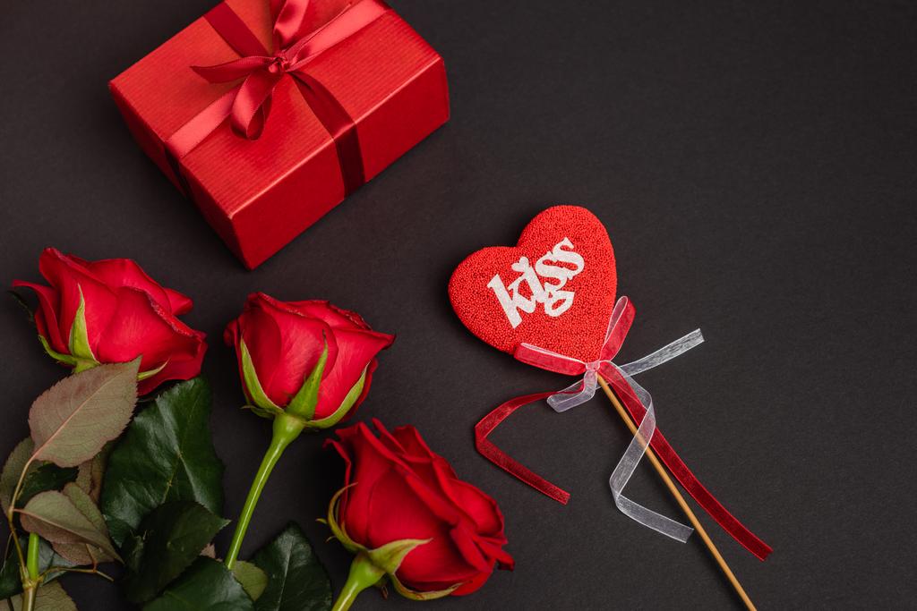 vista superior de rosas, presente dos namorados e coração no pau isolado no preto - Foto, Imagem