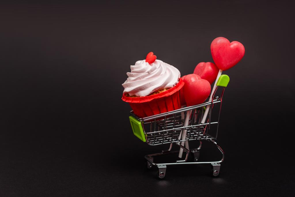 Sevgililer Günü pastası ve lolipopları olan bir alışveriş arabası. - Fotoğraf, Görsel