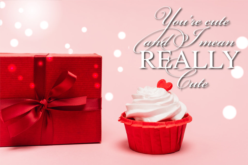 Valentines cupcake με κόκκινη καρδιά κοντά στο δώρο και είστε χαριτωμένο και εννοώ πραγματικά χαριτωμένο γράμματα σε ροζ φόντο - Φωτογραφία, εικόνα