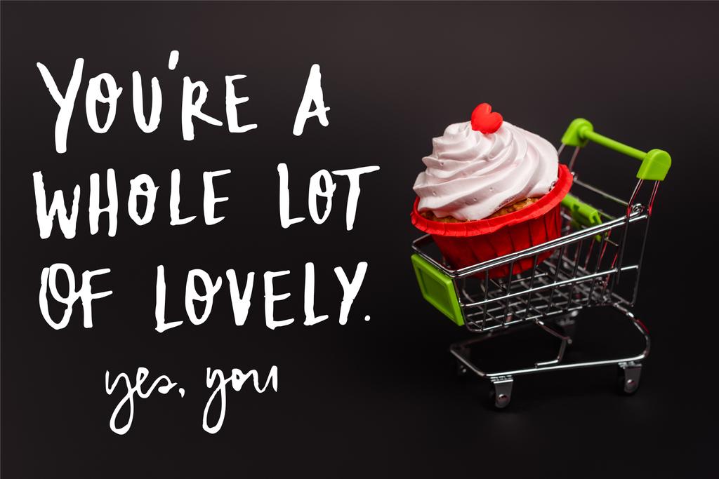 klein winkelwagentje met Valentijn cupcake in de buurt ben je een heleboel mooie, ja je belettering op zwart - Foto, afbeelding