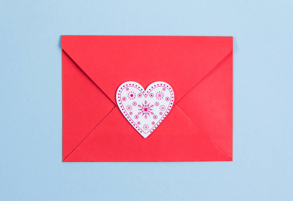 Sobre rojo con corazones rojos sobre fondo azul, espacio de copia Día de San Valentín - Foto, imagen
