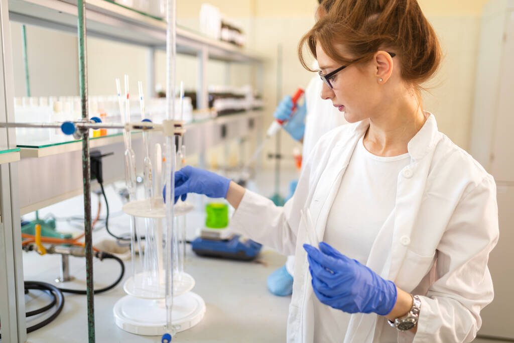 Naispuolinen opiskelija, kemian tutkija, työskentelee laboratoriossa - Valokuva, kuva