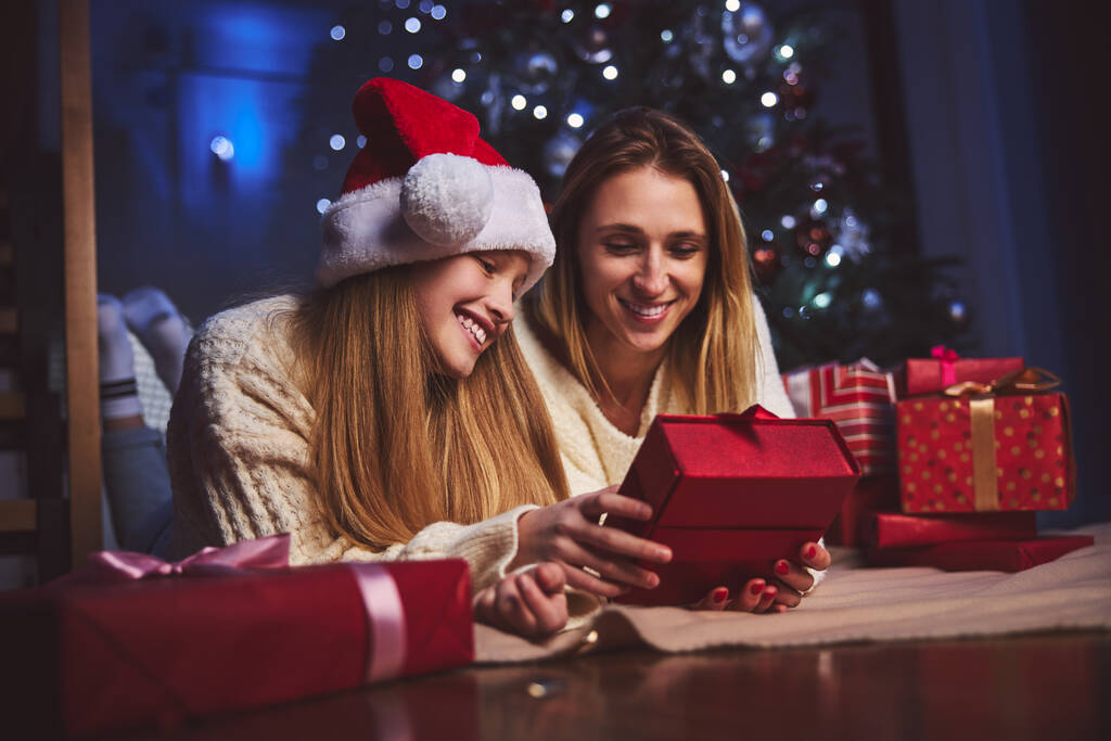 Gelukkige vrouw en haar dochter krijgen cadeautjes van de Kerstman - Foto, afbeelding