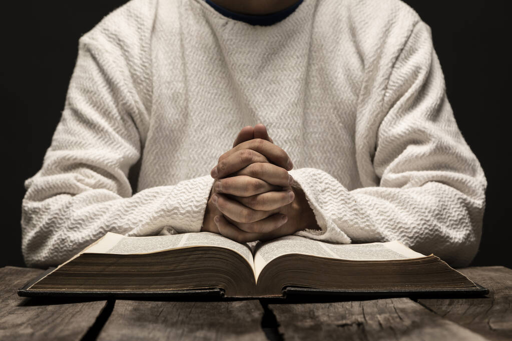 Jezus Chrystus Modląc się i czytając Pismo Święte w ciemną, czarną noc - Zdjęcie, obraz