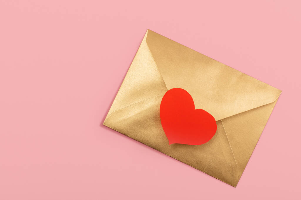 Золотий паперовий конверт з червоним серцем ізольовано на рожевому фоні
 - Фото, зображення