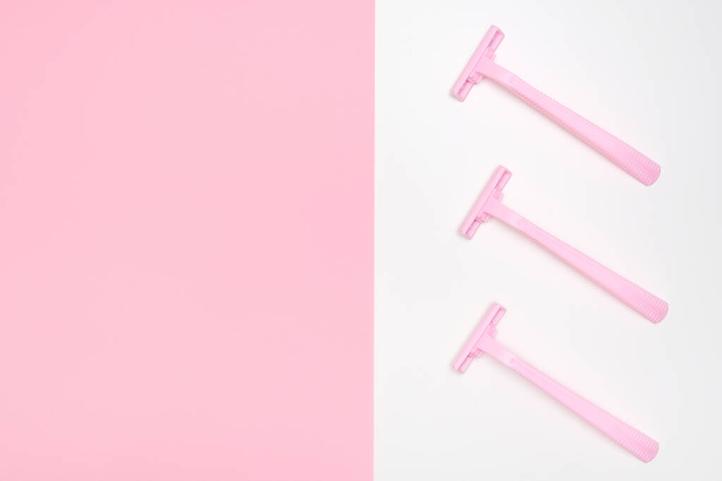 Rózsaszín eldobható műanyag nő borotvapenge borotválkozás, testápolás és vízmentes haj eltávolítása a lábak, hónalj és az arc, lapos feküdt másolási hellyel - Fotó, kép