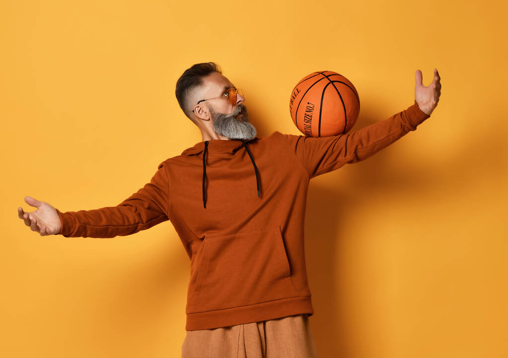 Бородатий чоловік показує трюк з кошиком м'яч студії постріл
 - Фото, зображення