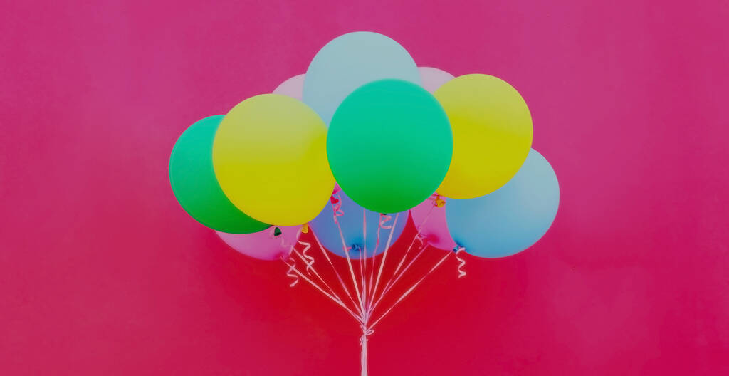 Close up bunch of festive colorful balloons on a pink background - Fotó, kép