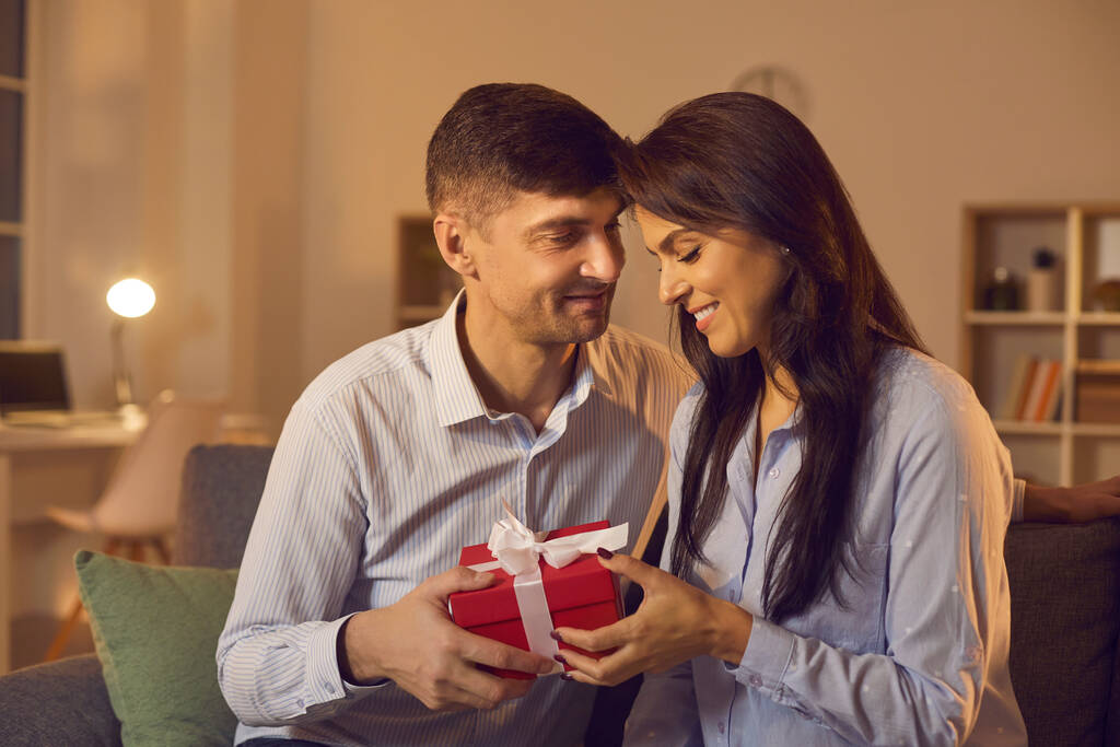 Jeune homme amoureux félicite tendrement sa petite amie le jour de la Saint-Valentin en lui donnant un cadeau. - Photo, image