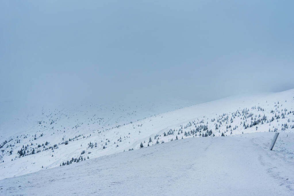 paysage hivernal incroyable. montagnes couvertes de neige et ciel nuageux bleu - Photo, image