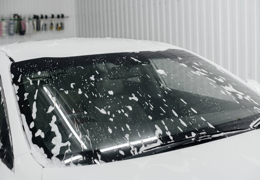 Moderní mytí s pěnou a vysokotlakou vodou z bílého auta. Myčka aut - Fotografie, Obrázek