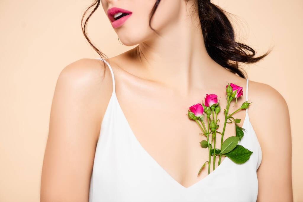 ピンク色に孤立した花の近くに驚くべき若い女性のクロップドビュー  - 写真・画像