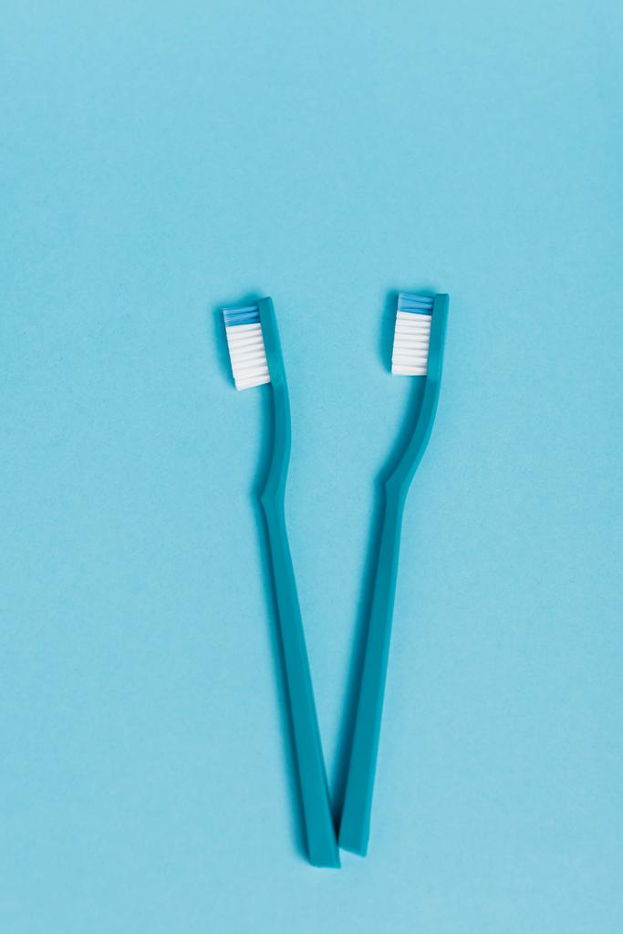 Bovenaanzicht van nieuwe tandenborstels op blauwe achtergrond - Foto, afbeelding