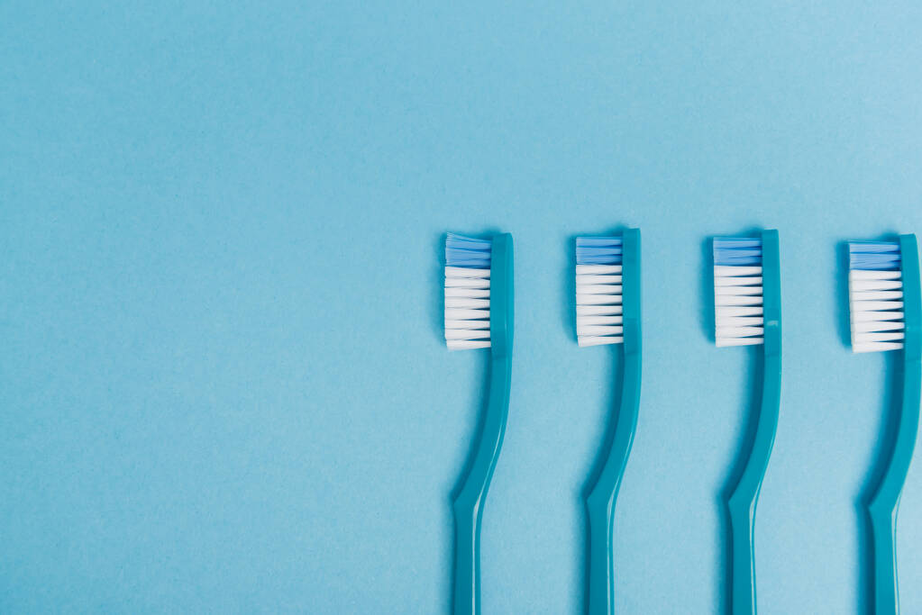 Mavi arkaplanda plastik diş fırçalarının üst görünümü - Fotoğraf, Görsel