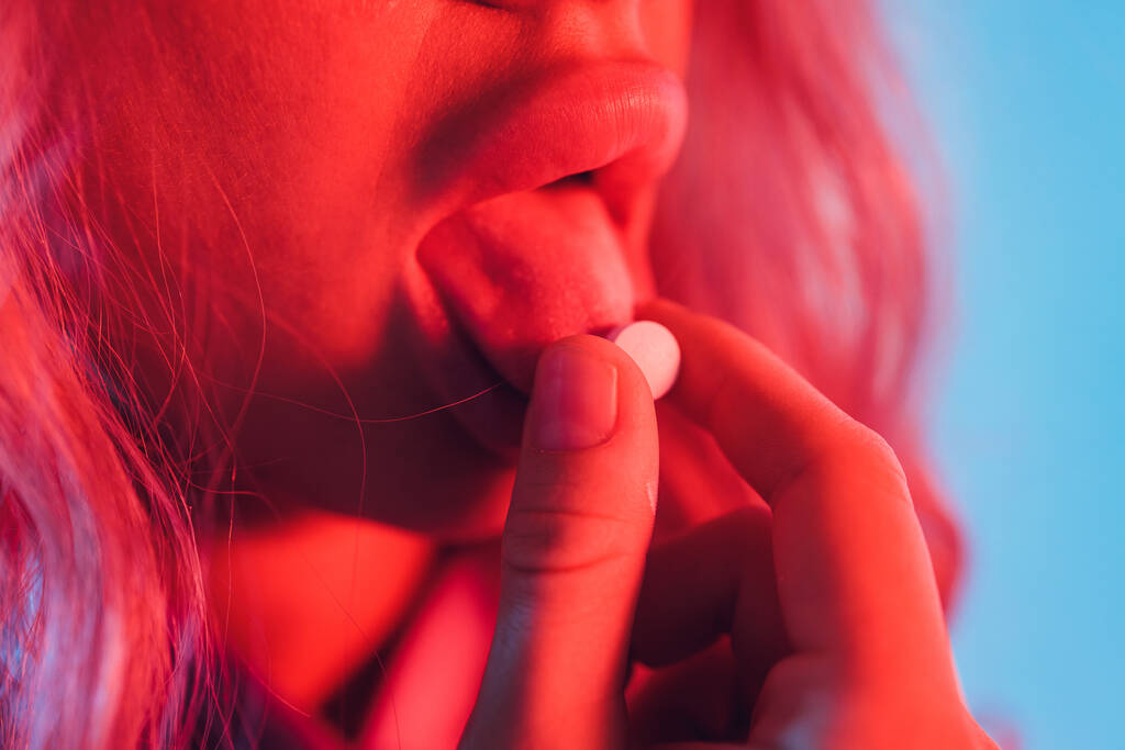 schöne Mädchen mit lsd auf der Zunge in Nachtclub mit rosa Rauch. - Foto, Bild