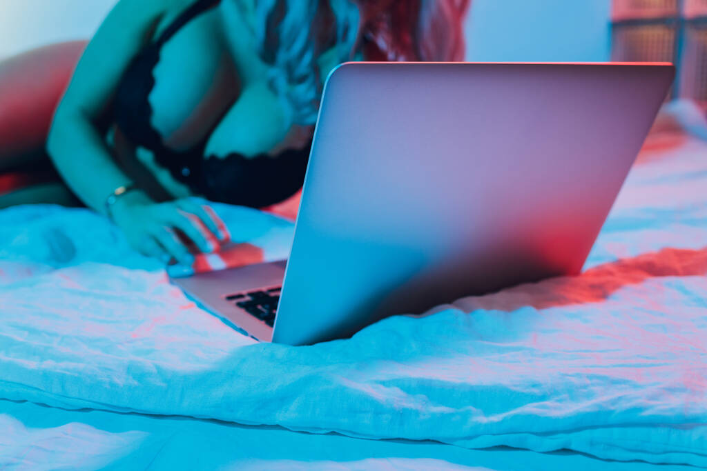 美しく、若い女の子は、 Webカメラの前でポーズをとって、性的モデルとして働いています。オンラインいちゃつくの概念,インターネット上のセックス. - 写真・画像