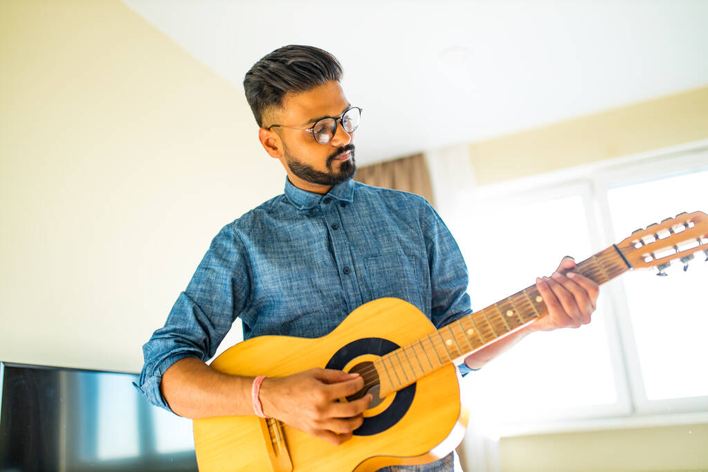 インド人男性がギターを弾いています - 写真・画像