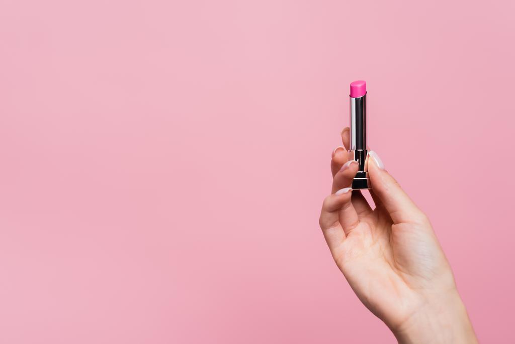cropped view of woman holding lipstick isolated on pink - Photo, Image