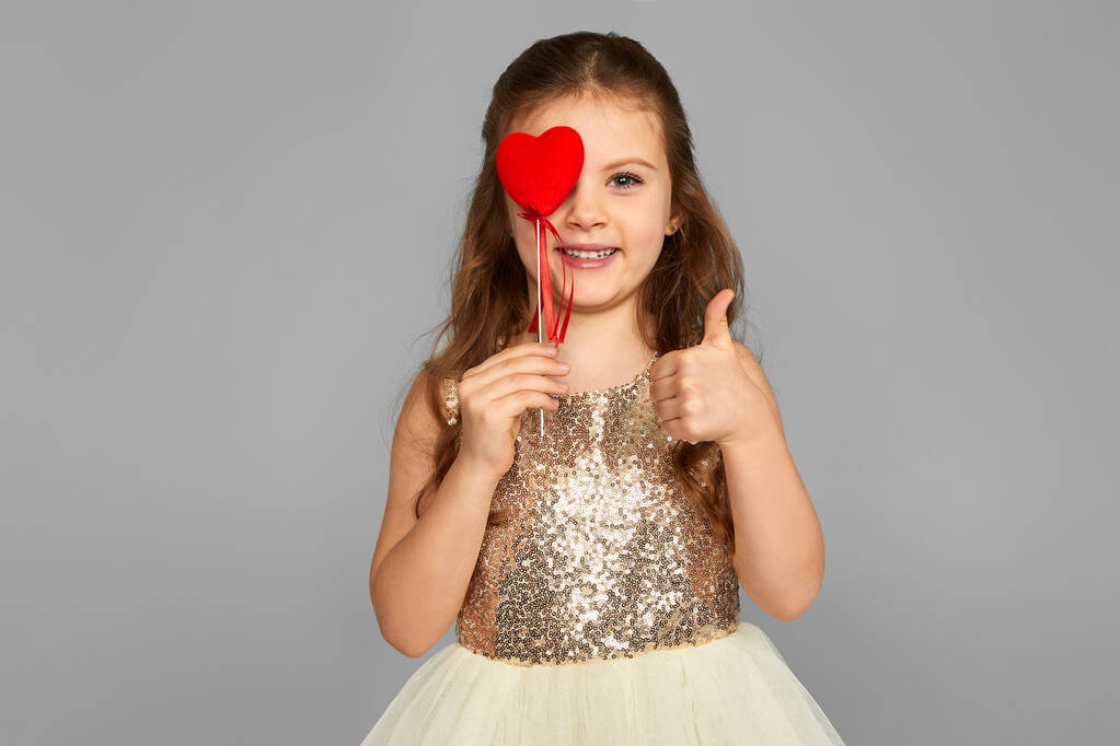 little child girl holding red heart on a stick - Photo, Image