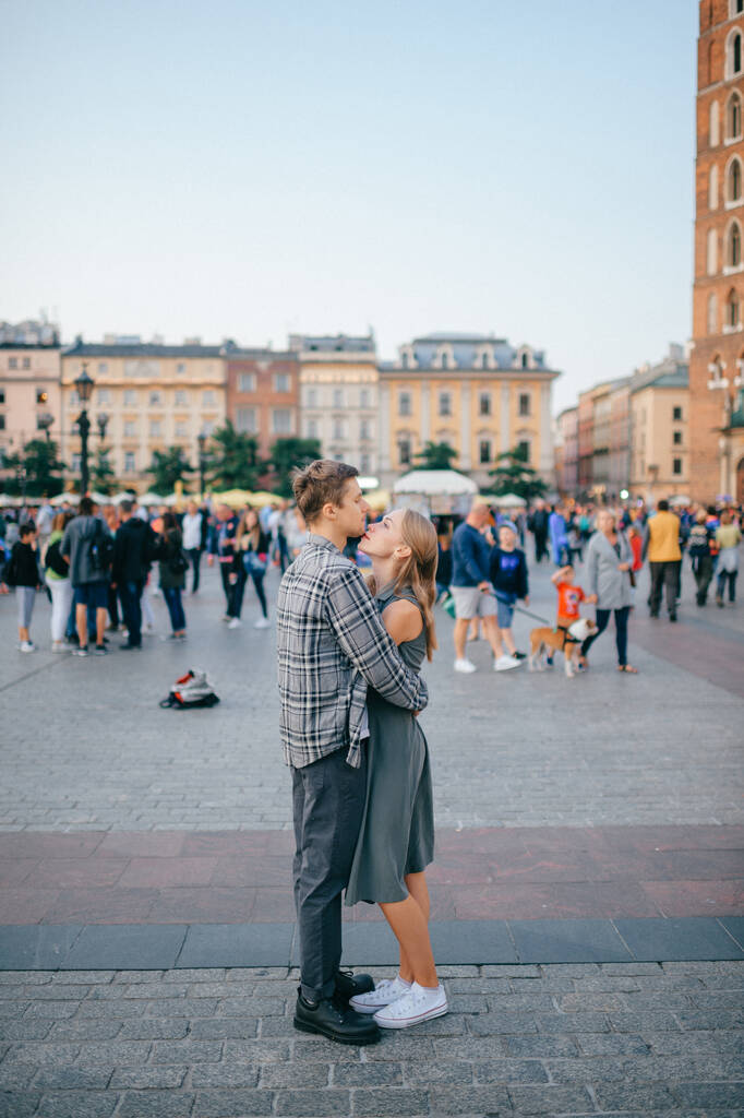 Jóvenes abrazos de pareja en la plaza central de Cracovia (Cracovia) - Foto, imagen