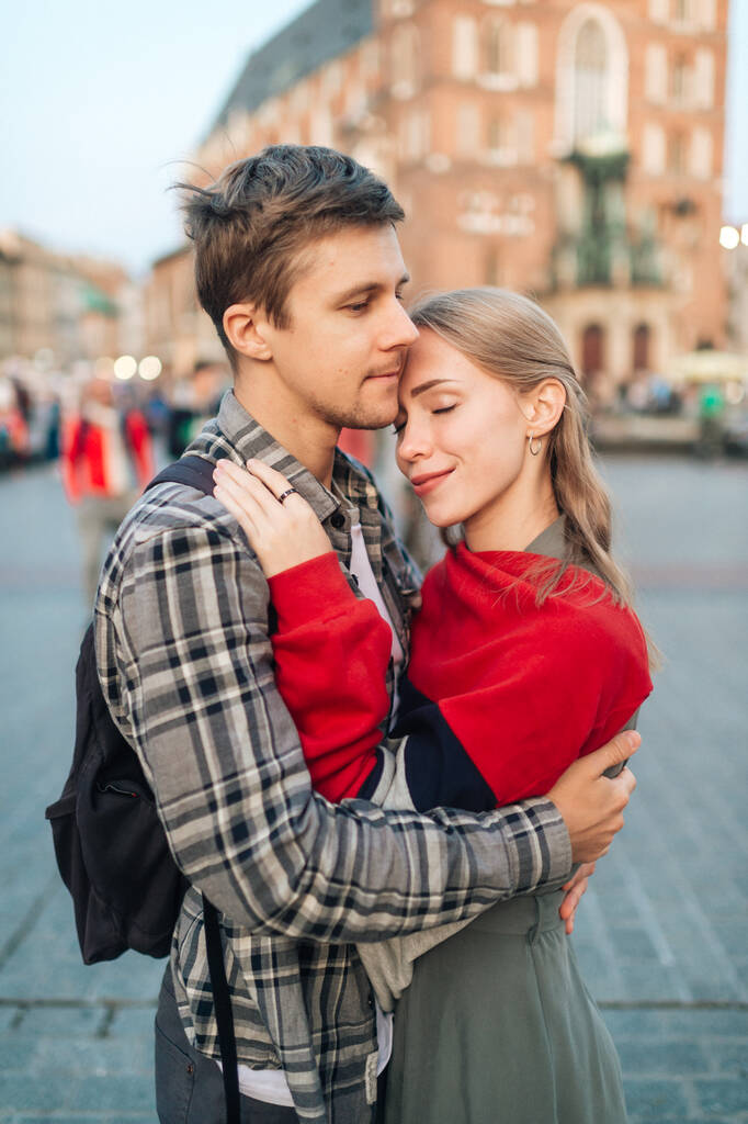 Jonge liefdevolle paar knuffels op het centrale plein in Krakau (Krakau) - Foto, afbeelding