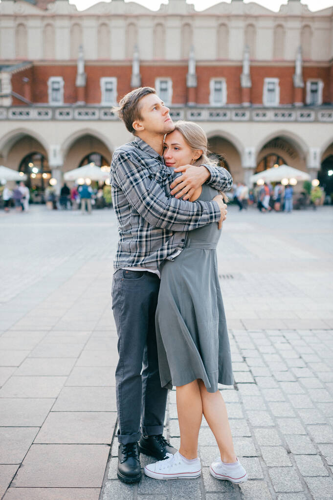 Jóvenes abrazos de pareja en la plaza central de Cracovia (Cracovia) - Foto, imagen