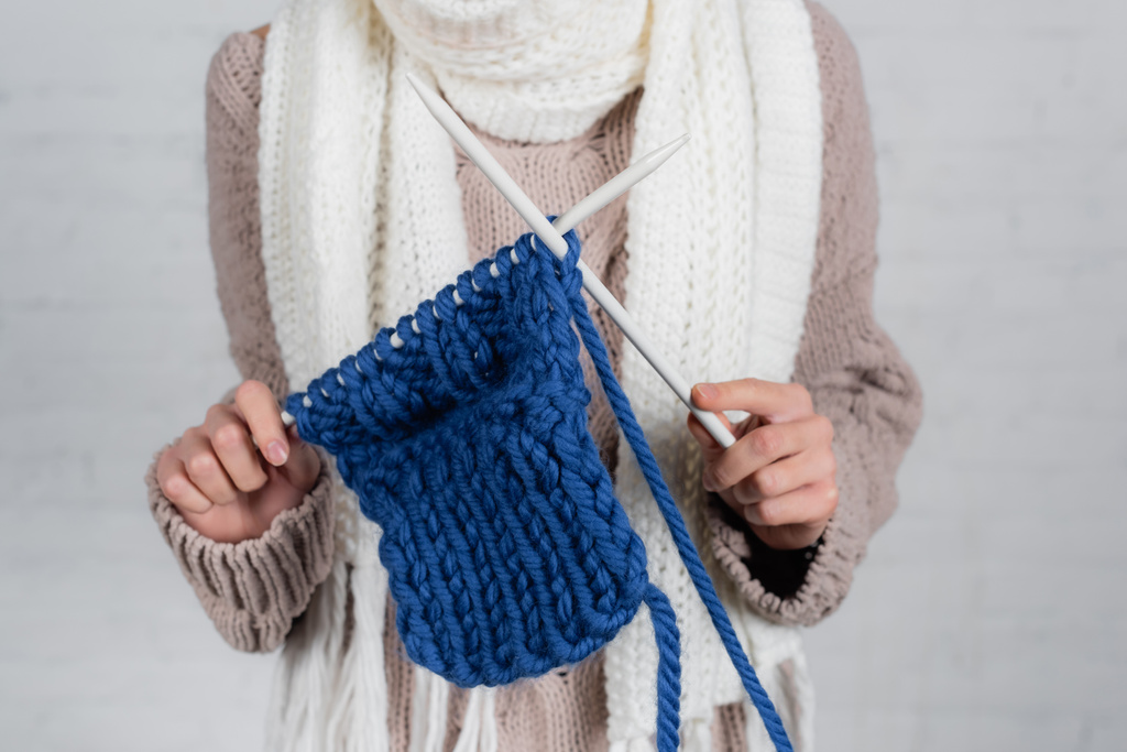Vista ritagliata della donna che lavora a maglia con il filato di lana su sfondo bianco - Foto, immagini