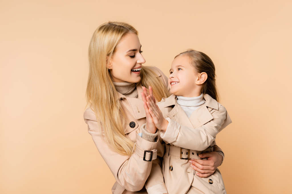 iloinen blondi äiti ja hymyilevä tytär antaa yläfemma eristetty beige - Valokuva, kuva