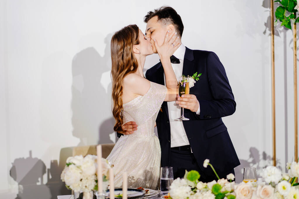 recién casados con champán en las manos escuchan brindis, felicitaciones y beso - Foto, Imagen