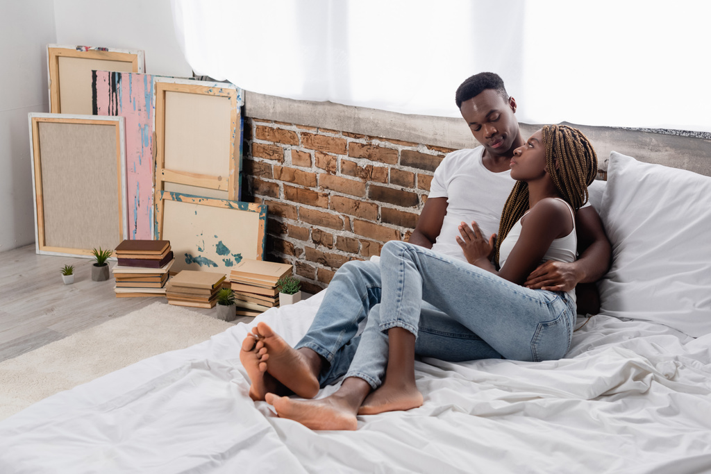 Joven pareja afroamericana abrazándose en la cama en casa  - Foto, imagen
