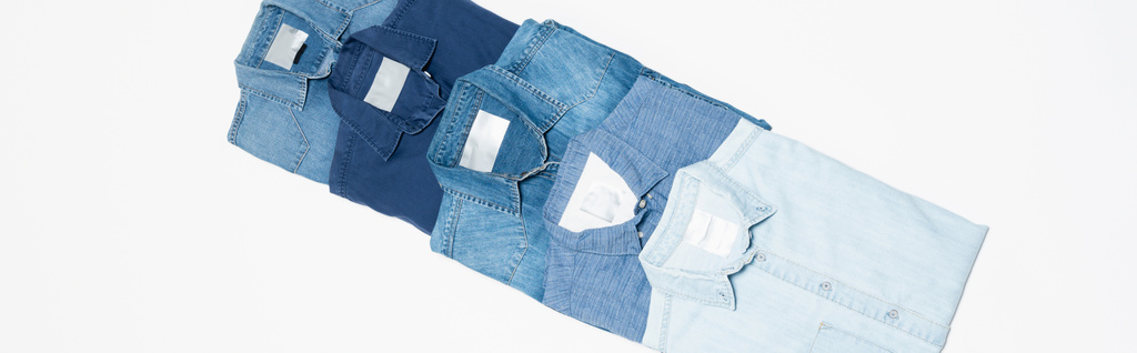 diagonální řada různých džínových košil na bílém pozadí, horní pohled, banner - Fotografie, Obrázek