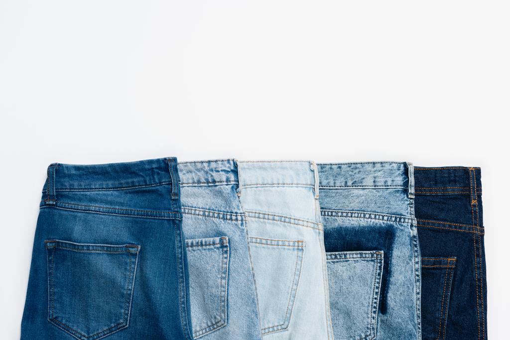 linha horizontal de jeans azul diferente isolado em branco, vista superior - Foto, Imagem
