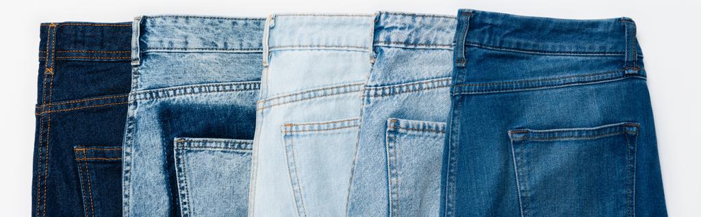 horizontale Reihe verschiedener Jeans isoliert auf weißem Untergrund, Ansicht von oben, Banner - Foto, Bild