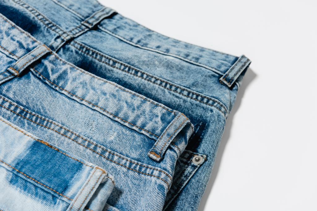 zblízka pohled na pár modrých džínů na bílém pozadí - Fotografie, Obrázek